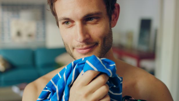 Coral Waschmittelwerbung mit einem jungen attraktiven Mann der seine Wäsche wäscht